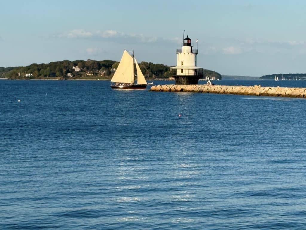 Spring Point Ledge Lighthouse in South Portland, Maine with a sailboat passing by on a clear fall day — a peaceful moment from my Maine Coastal getaway.